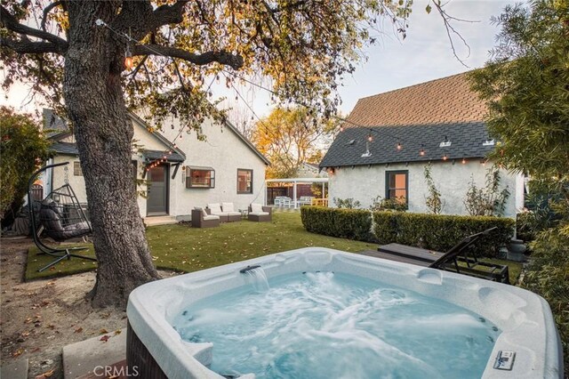 view of swimming pool featuring an outdoor hangout area, a hot tub, and a lawn