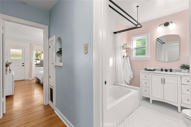 bathroom featuring vanity, a bath, and toilet