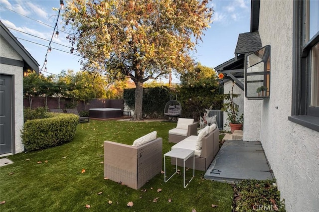 view of yard featuring a patio area, a fenced backyard, an outdoor living space, and a hot tub