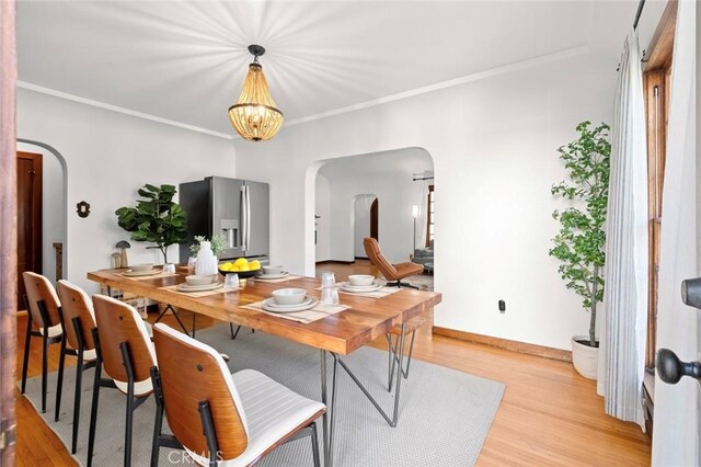 dining room featuring ornamental molding, light hardwood / wood-style floors, and a chandelier