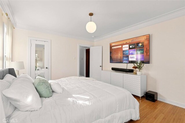 bedroom with crown molding and hardwood / wood-style flooring