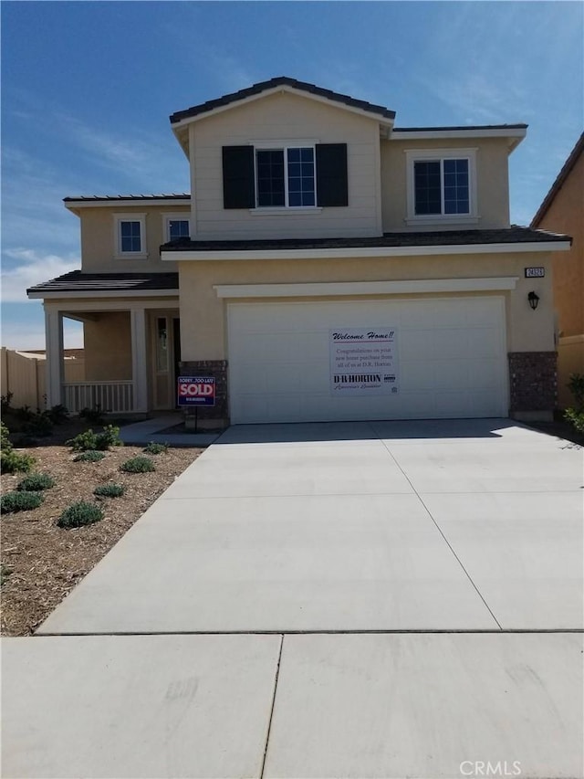 view of property with a garage and covered porch