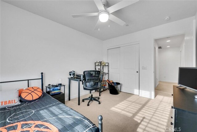 carpeted bedroom featuring ceiling fan and a closet