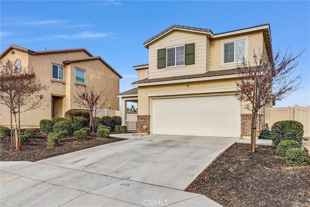 traditional-style house with stucco siding, driveway, an attached garage, and fence