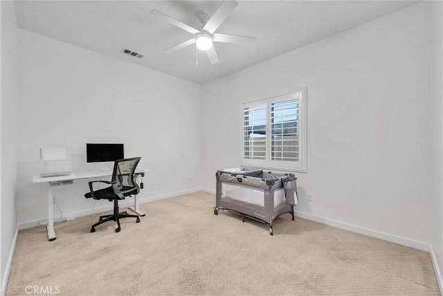 carpeted office space with baseboards, visible vents, and a ceiling fan