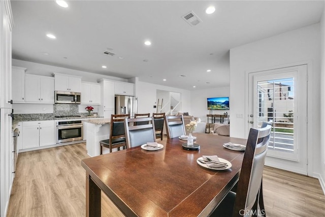 dining space with light wood-style floors, recessed lighting, and visible vents