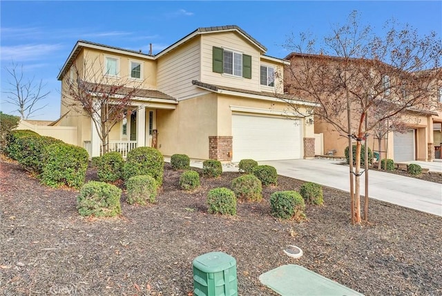 view of front of house with a garage, concrete driveway, covered porch, and stucco siding