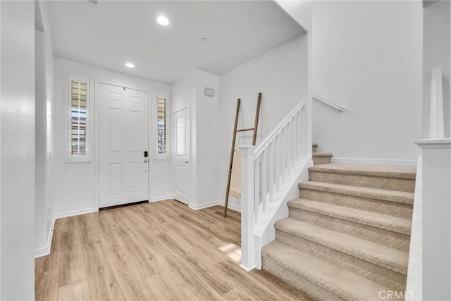 entryway with stairs, recessed lighting, light wood-type flooring, and baseboards