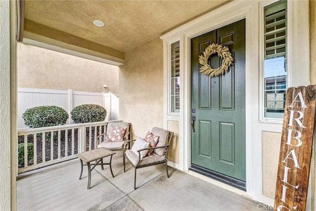 view of exterior entry with covered porch and stucco siding