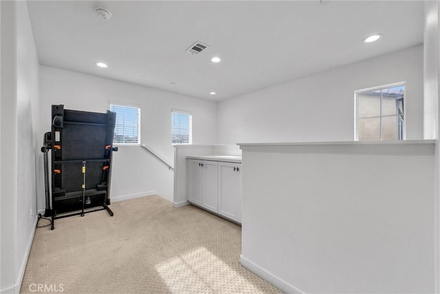 interior space featuring recessed lighting, light colored carpet, visible vents, baseboards, and an upstairs landing