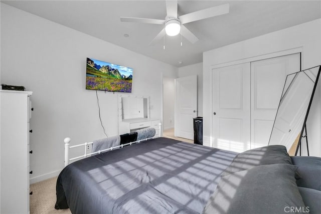 carpeted bedroom featuring a ceiling fan, baseboards, and a closet