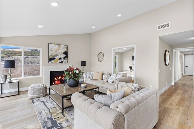 31002 Flying Cloud Dr, Laguna Niguel, CA 92677 - living area with lofted ceiling, wood finished floors, recessed lighting, and a lit fireplace