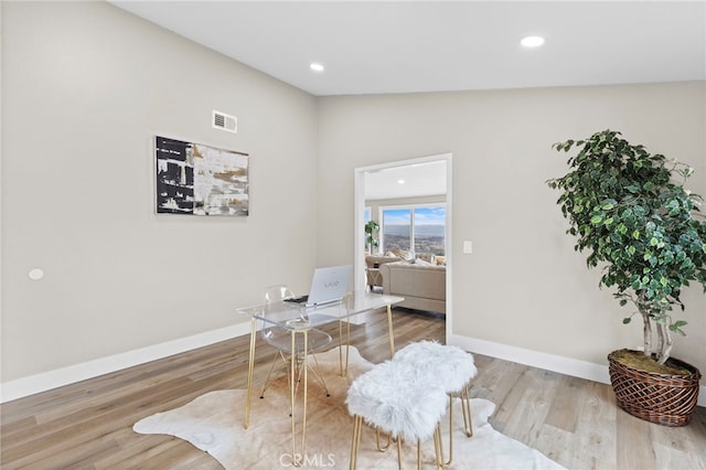 office with lofted ceiling and light hardwood / wood-style floors