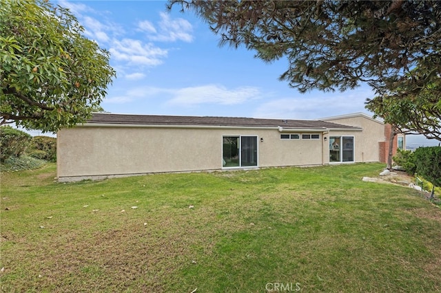 rear view of property featuring a yard