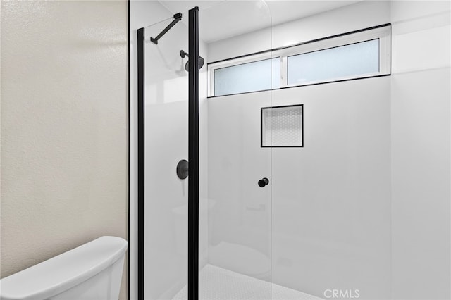 bathroom with an enclosed shower and toilet