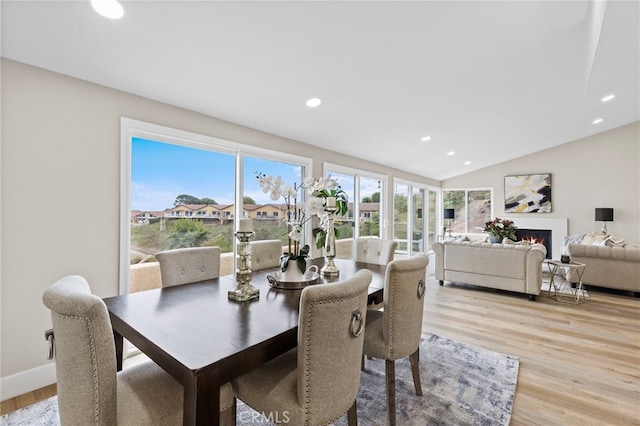 dining room featuring vaulted ceiling and light hardwood / wood-style flooring