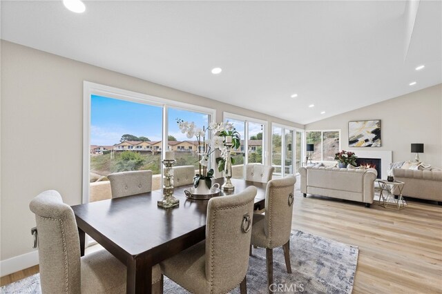 31002 Flying Cloud Dr, Laguna Niguel, CA 92677 - dining space with recessed lighting, light wood-type flooring, vaulted ceiling, and a warm lit fireplace