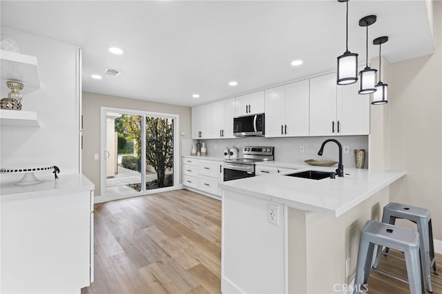 31002 Flying Cloud Dr, Laguna Niguel, CA 92677 - kitchen with stainless steel appliances, a peninsula, white cabinetry, tasteful backsplash, and a breakfast bar area