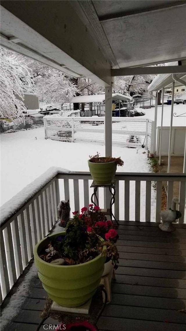 view of snow covered back of property