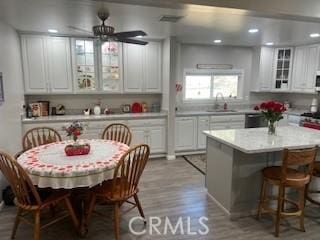 kitchen with light wood-style flooring, white cabinets, a sink, and light countertops