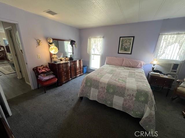 carpeted bedroom featuring visible vents