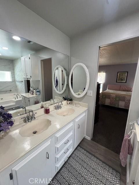 bathroom with a garden tub, a sink, and double vanity