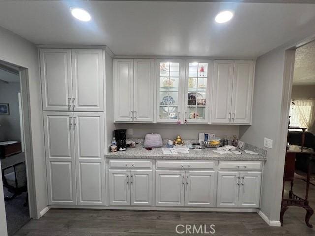 bar featuring baseboards, dark wood-style flooring, and recessed lighting