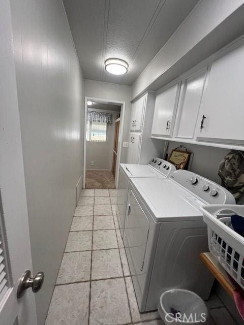 clothes washing area featuring cabinet space, a textured ceiling, and independent washer and dryer