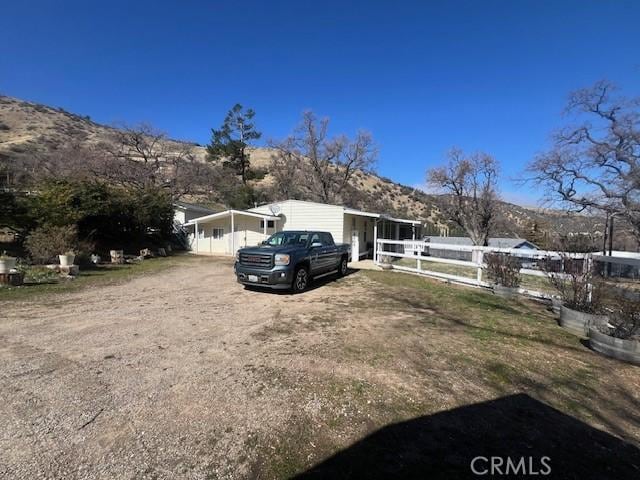 view of front facade with fence and dirt driveway