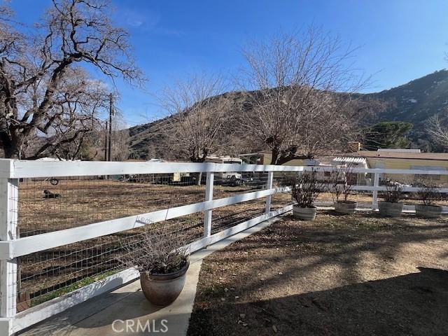 view of yard featuring a mountain view and fence