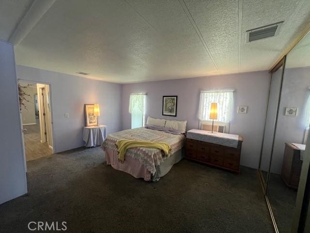 carpeted bedroom featuring visible vents, a textured ceiling, and multiple windows