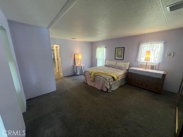 carpeted bedroom with visible vents and a textured ceiling