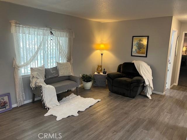 living room with baseboards and wood finished floors