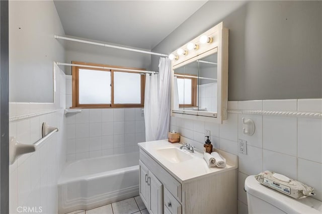 full bathroom featuring tile walls, vanity, toilet, tile patterned floors, and shower / bath combo with shower curtain