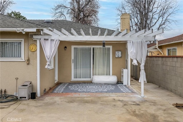 rear view of property featuring a pergola and a patio