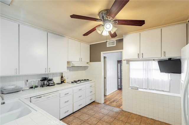 kitchen with white cabinetry, sink, white appliances, and tile countertops