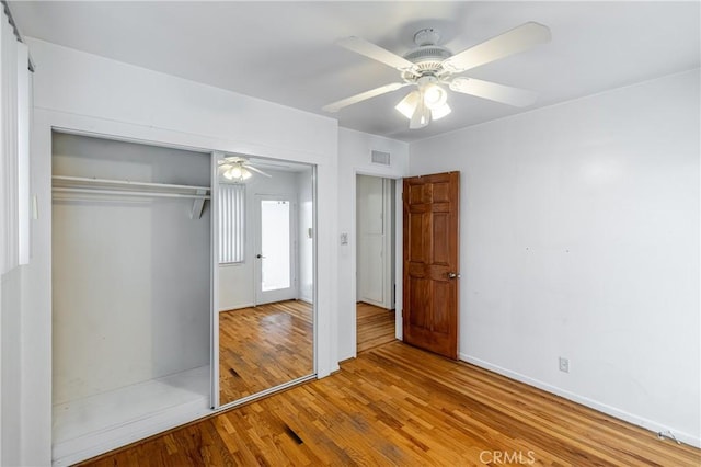 unfurnished bedroom featuring a closet, ceiling fan, and light wood-type flooring