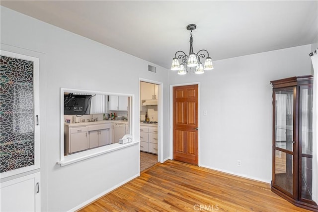 interior space featuring a notable chandelier and light hardwood / wood-style floors