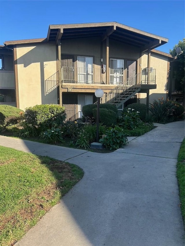 view of front of home with stairs and stucco siding