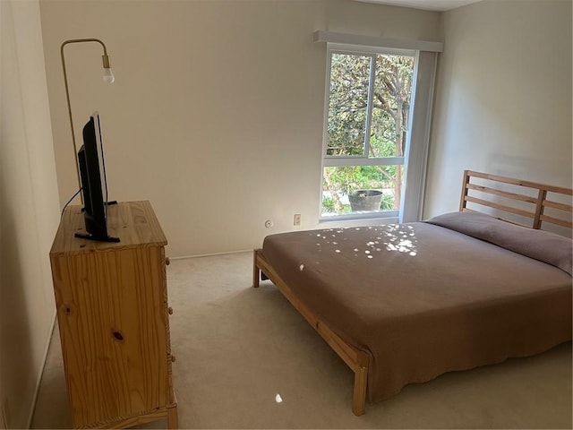 bedroom with baseboards and light colored carpet