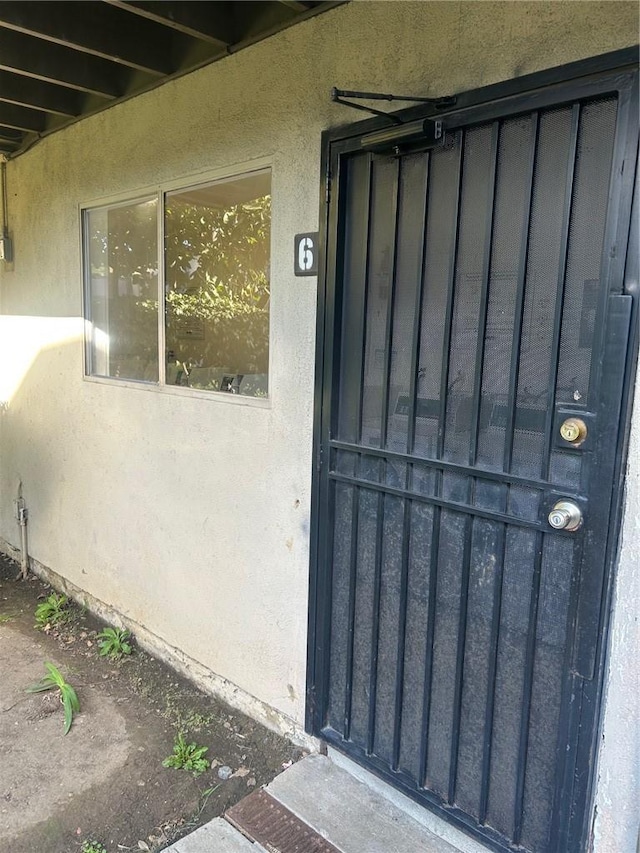 property entrance featuring board and batten siding and stucco siding