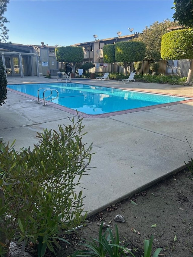 pool featuring a patio area and fence