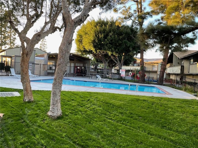 view of pool with a yard and fence