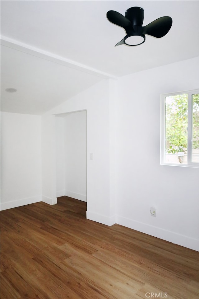 empty room with vaulted ceiling, dark hardwood / wood-style floors, and ceiling fan