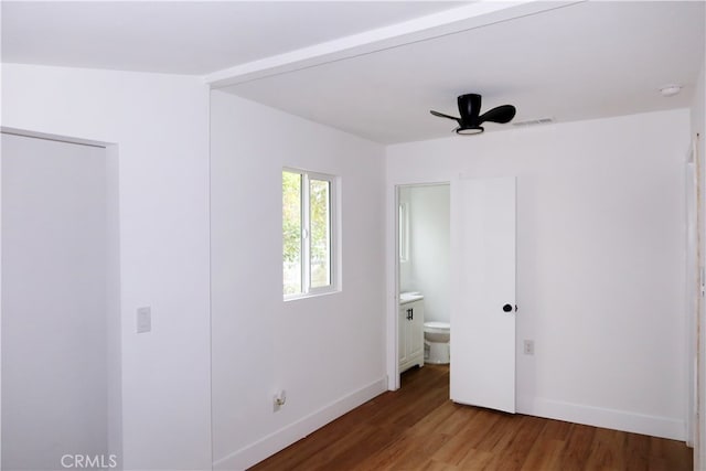 unfurnished bedroom with ensuite bath and hardwood / wood-style floors