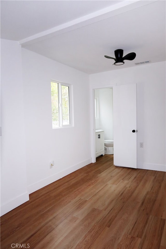 unfurnished bedroom featuring connected bathroom and hardwood / wood-style floors