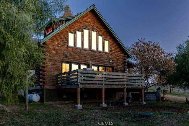 back of house with log siding and a wooden deck