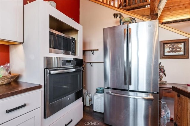 kitchen featuring dark countertops, white cabinetry, and stainless steel appliances