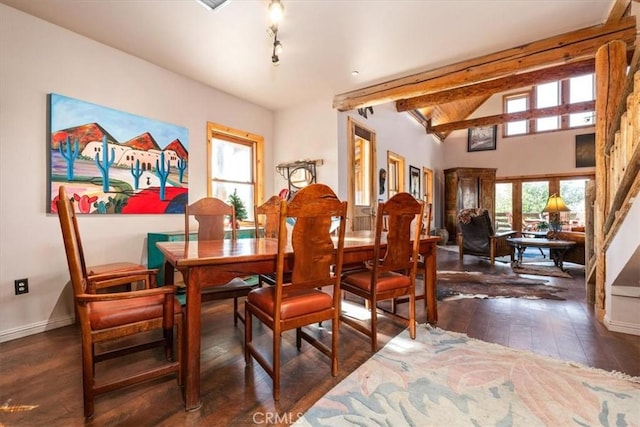 dining room with vaulted ceiling with beams, a healthy amount of sunlight, dark wood finished floors, and baseboards