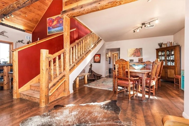 dining space with vaulted ceiling, dark wood-style flooring, stairway, and rail lighting